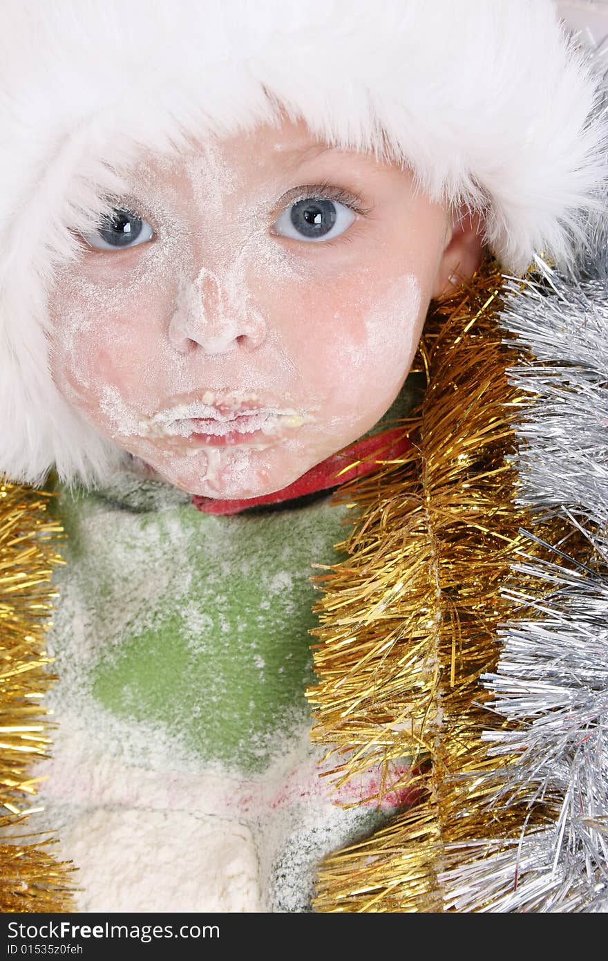 Toddler wearing a christmas hat, covered in flour. Toddler wearing a christmas hat, covered in flour