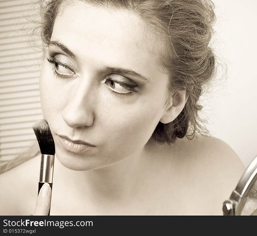 closeup of woman applying loose powder with thick black brush. closeup of woman applying loose powder with thick black brush