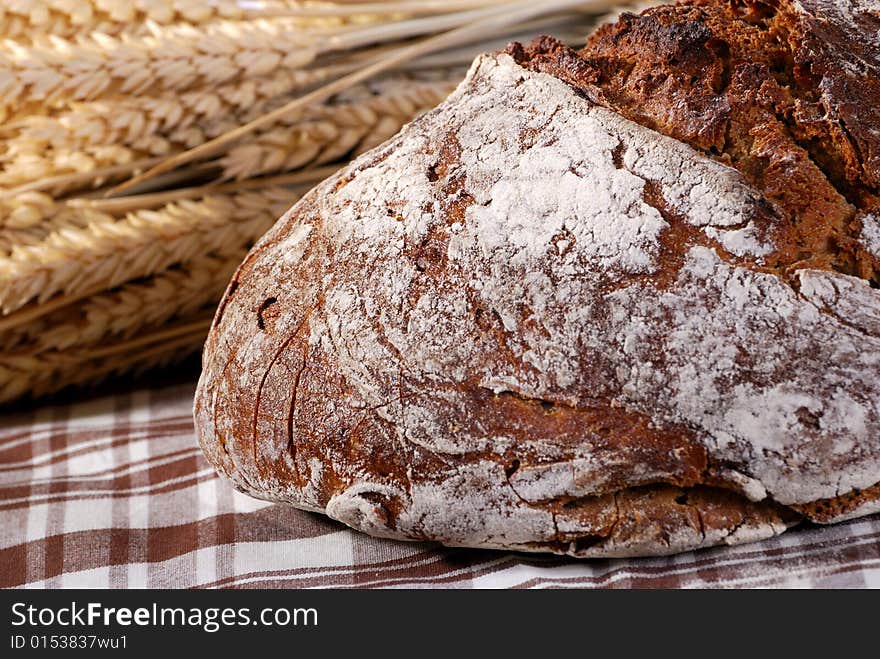 Tasty bread with crust in front of corn