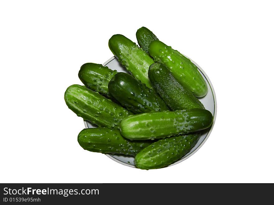 Cucumbers on a plate, it is isolated on a white background. Cucumbers on a plate, it is isolated on a white background