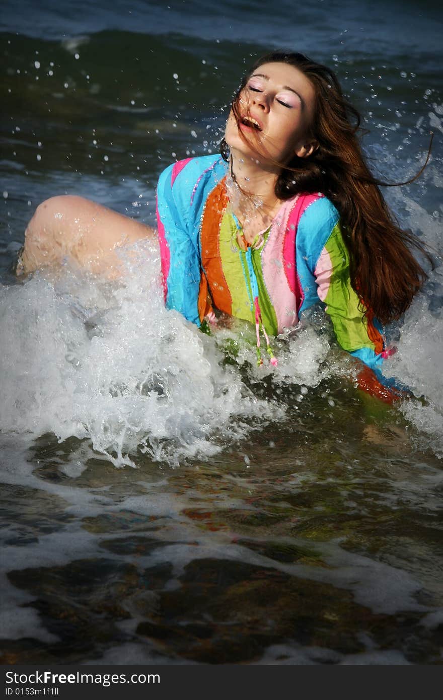 A brunette young beautiful woman wet by the sea water