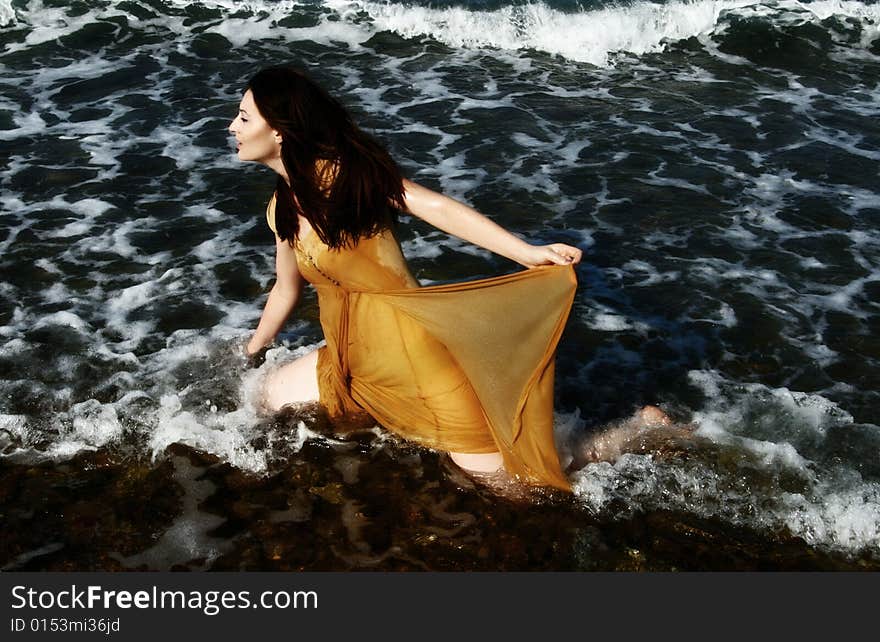 A brunette young beautiful woman wet by the sea water