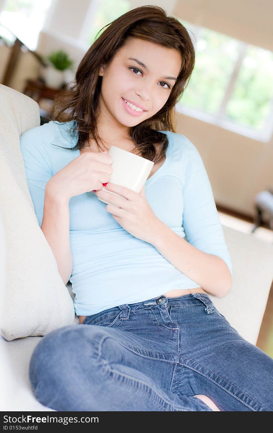 An attractive young woman drinking coffee at home. An attractive young woman drinking coffee at home