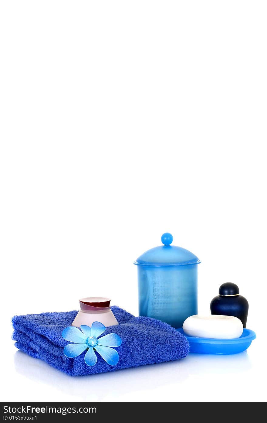 Spa essentials in blue on white background, reflective surface, copy space. Spa essentials in blue on white background, reflective surface, copy space