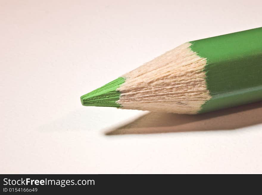 A green pencil lying diagonal on a table. A green pencil lying diagonal on a table.