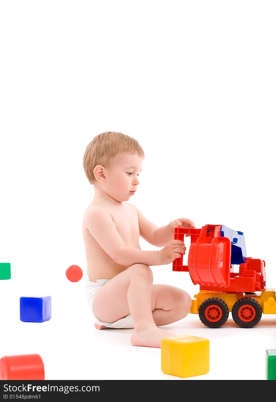 Little boy play with toys over white background with light shadows.