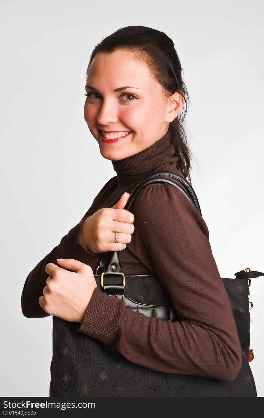 Portrait of the charming girl with dark hair with bag on a light background