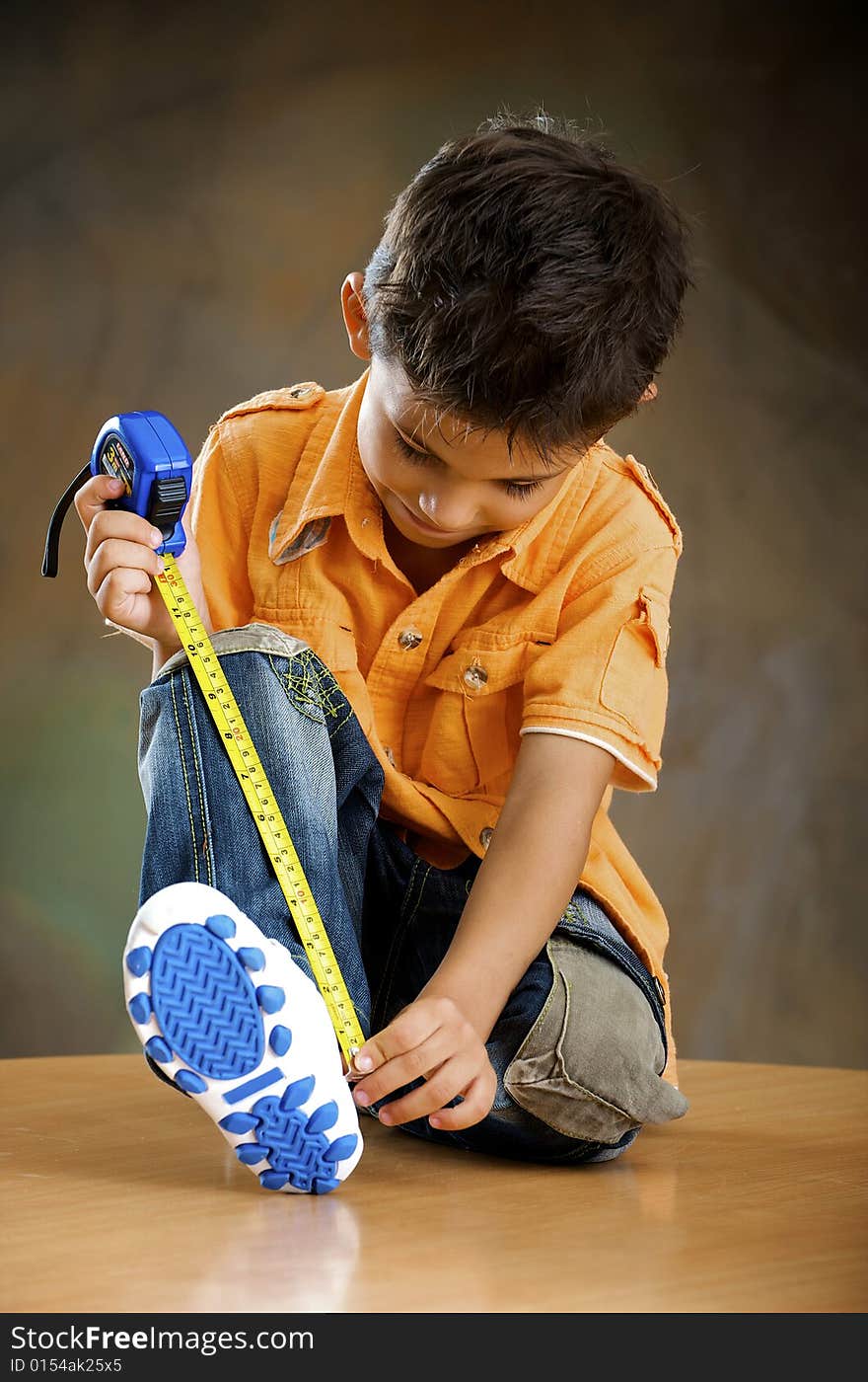 Boy is measured his foot. Boy is measured his foot