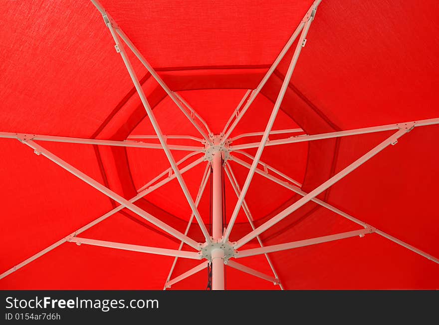 Metal skeleton of a red umbrella.