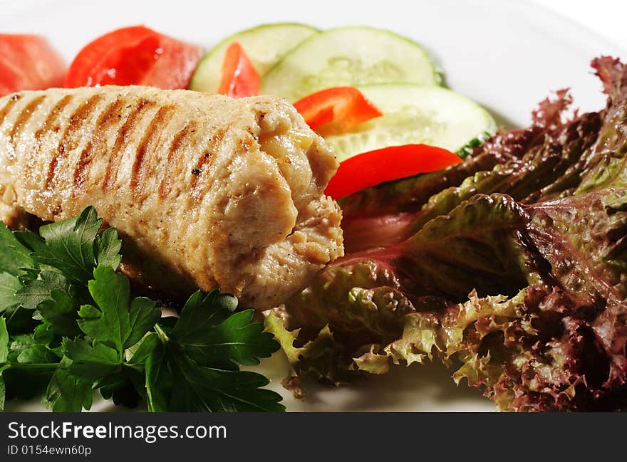 Pork (or Beef) Grilled Roll with Greens and Vegetables on a Plate. Isolated on White Background. Pork (or Beef) Grilled Roll with Greens and Vegetables on a Plate. Isolated on White Background