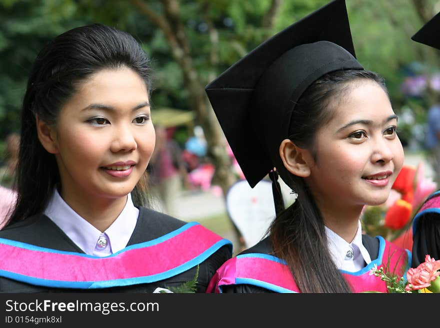 Beautiful Asian university graduates celebrate their success.