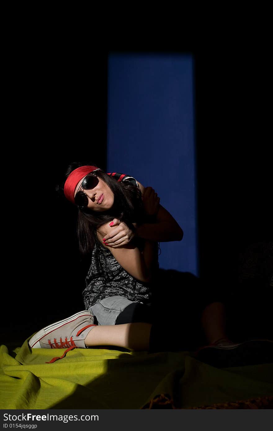 Woman sitting on a floor lit from another room with half closed door. Strong shadow. Woman sitting on a floor lit from another room with half closed door. Strong shadow