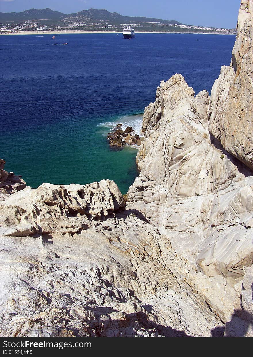 The view of rocks and Cabo San Lucas resort town in a background (Mexico). The view of rocks and Cabo San Lucas resort town in a background (Mexico).