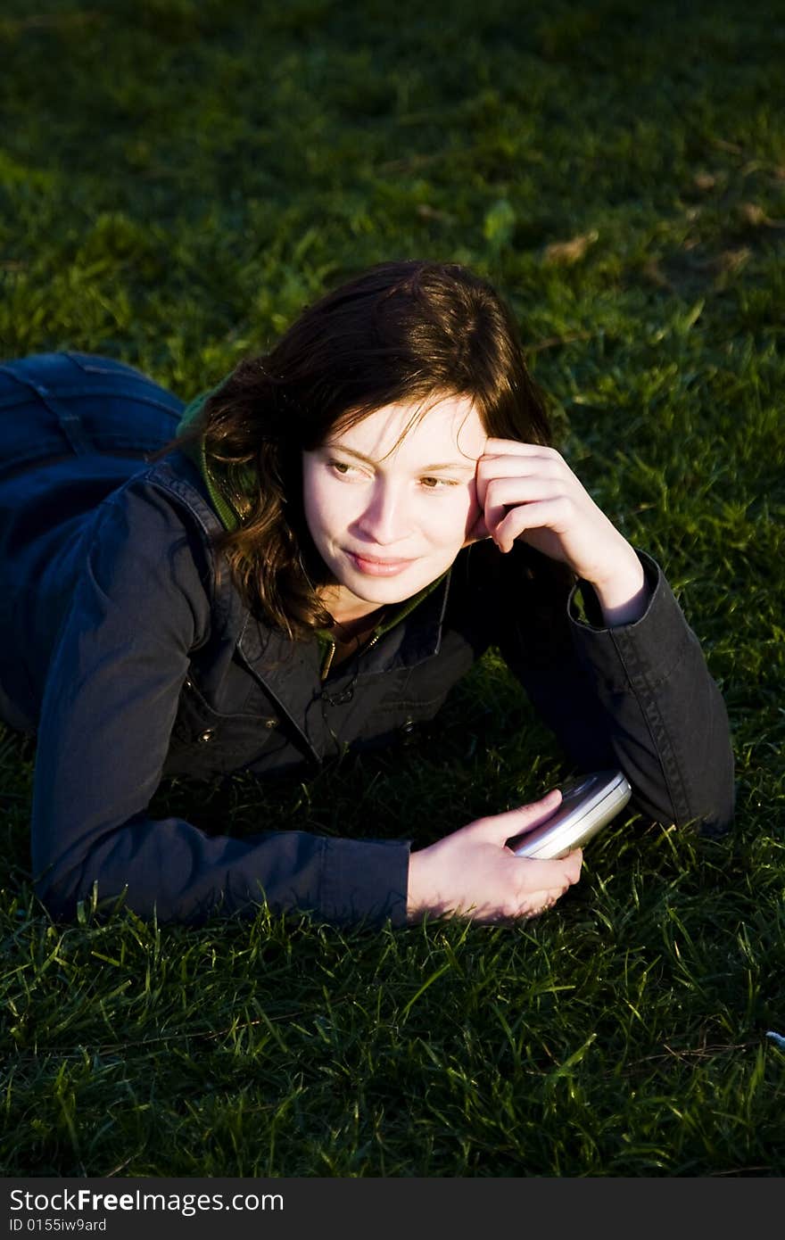 Young woman listening music at sunset time.