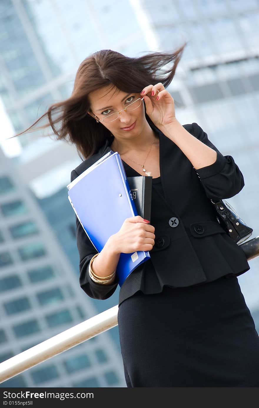 Business woman with documents outside a modern office building