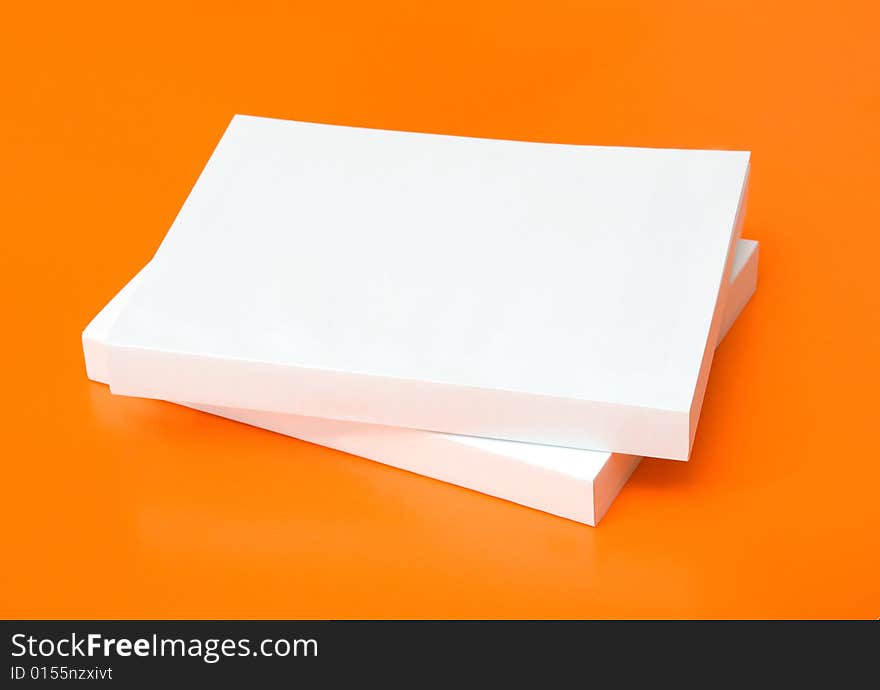 Two blank books over an orange background