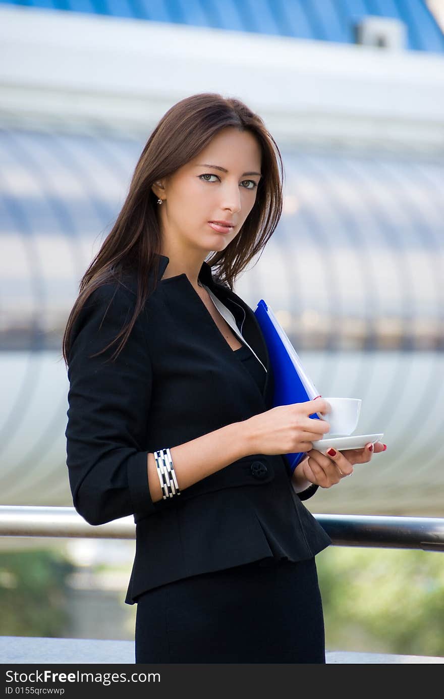 Business woman drinks a coffee outdoors in modern downtown. Business woman drinks a coffee outdoors in modern downtown