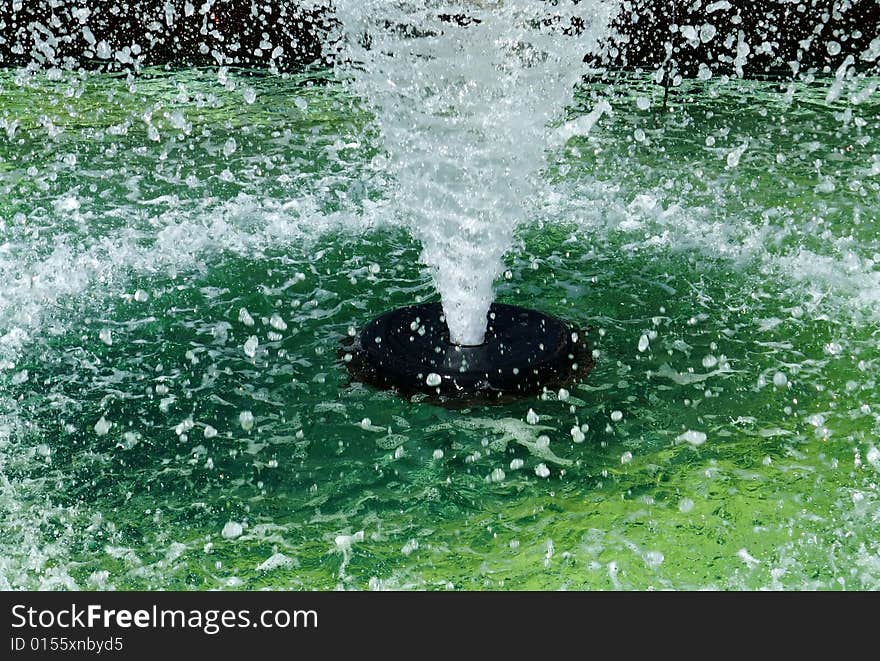 Abstract Closeup of Public Fountain with High Spray of Green Water. Abstract Closeup of Public Fountain with High Spray of Green Water