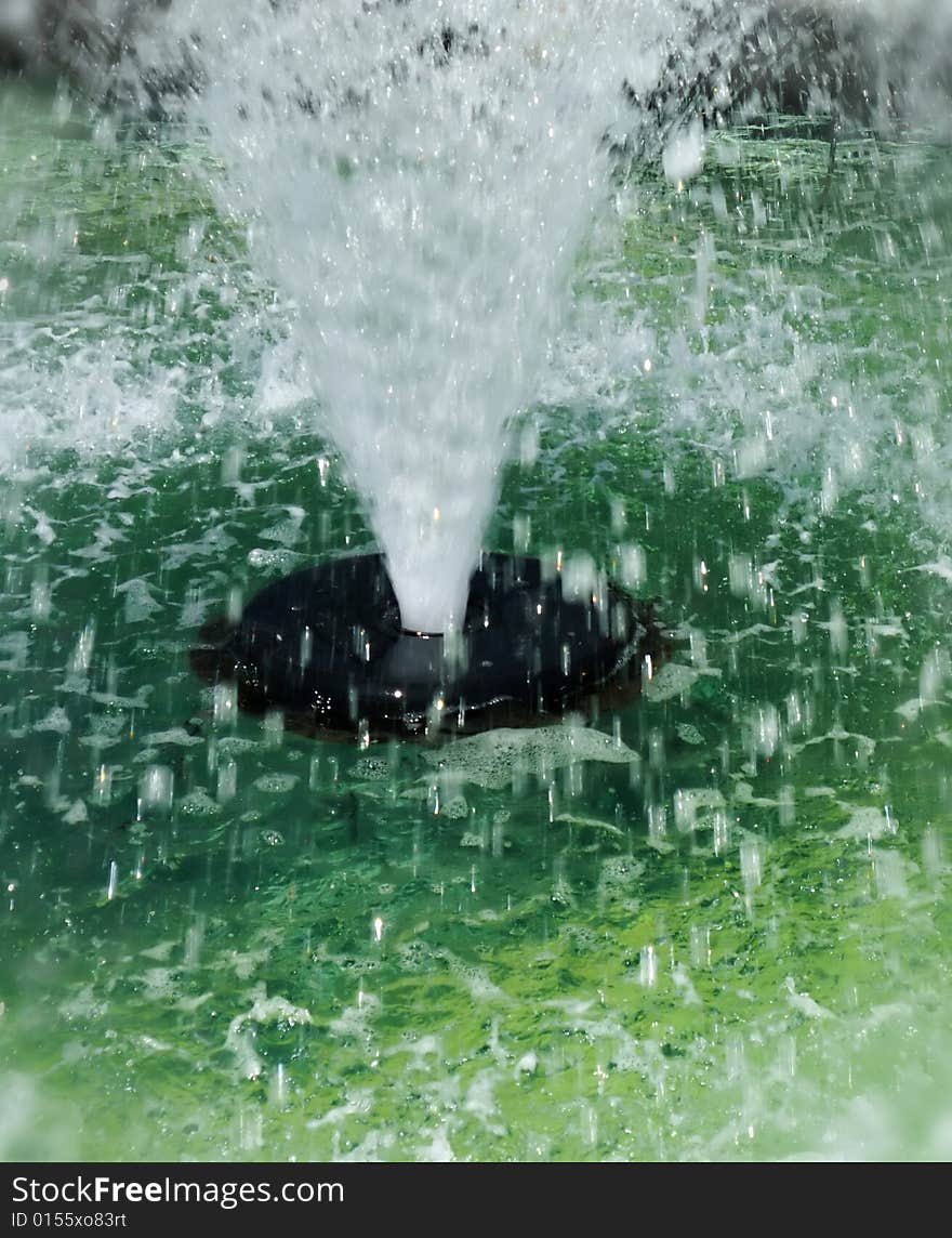 Abstract Closeup of Public Fountain with High Spray of Green Water. Abstract Closeup of Public Fountain with High Spray of Green Water