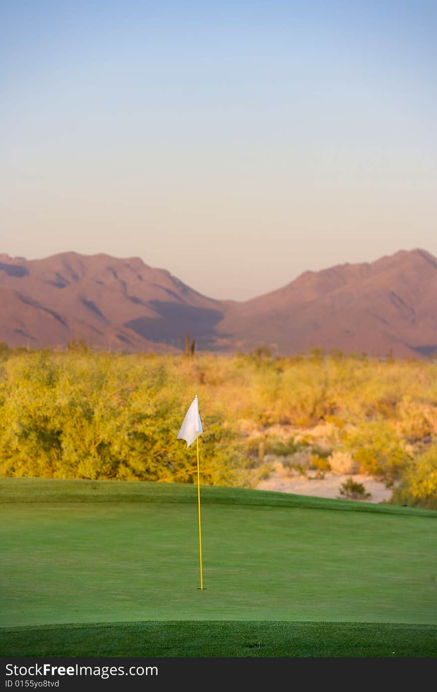 Golf course in the Arizona desert with mountains in the late afternoon sun