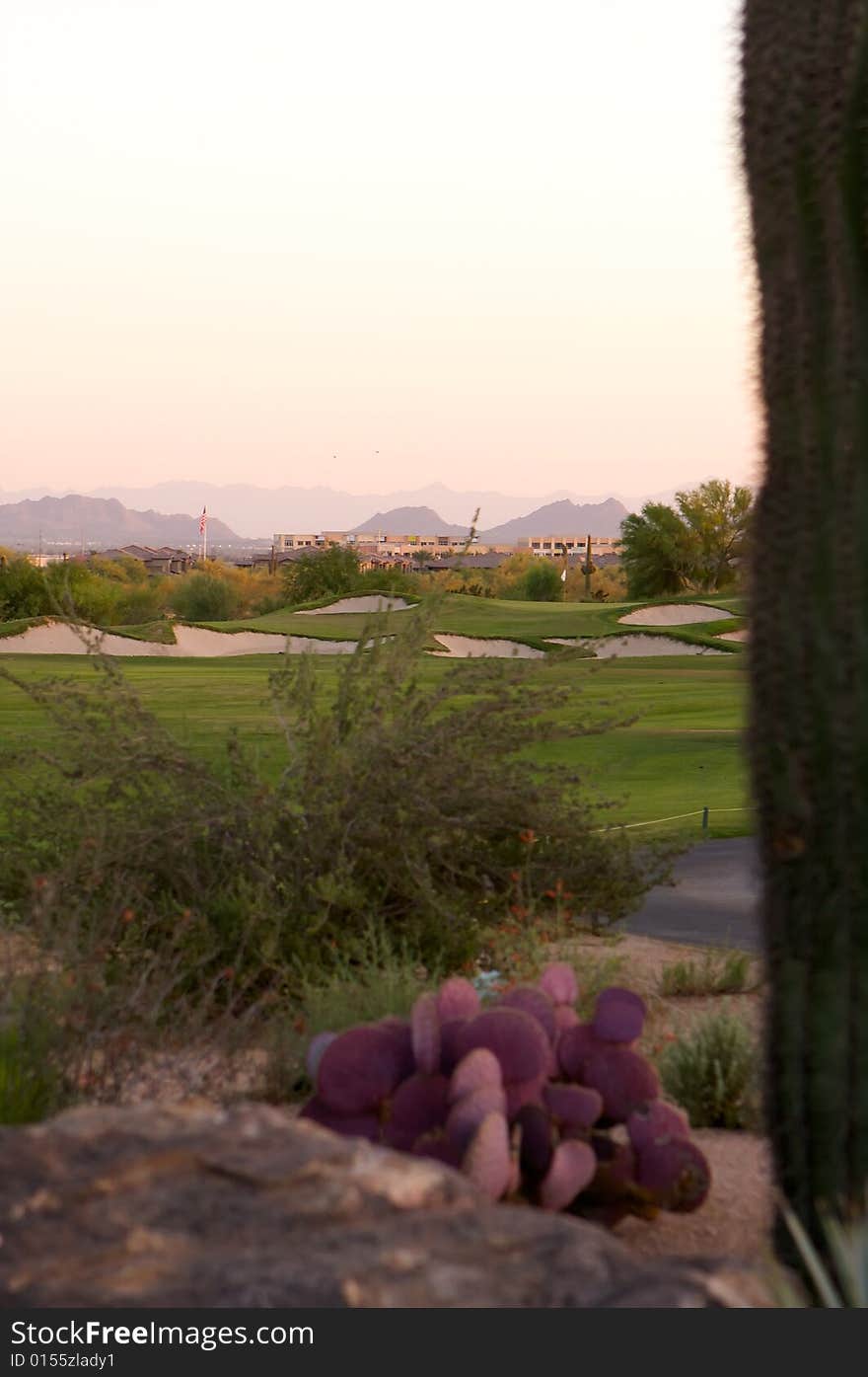 Golf course in the Arizona desert with mountains in the late afternoon sun