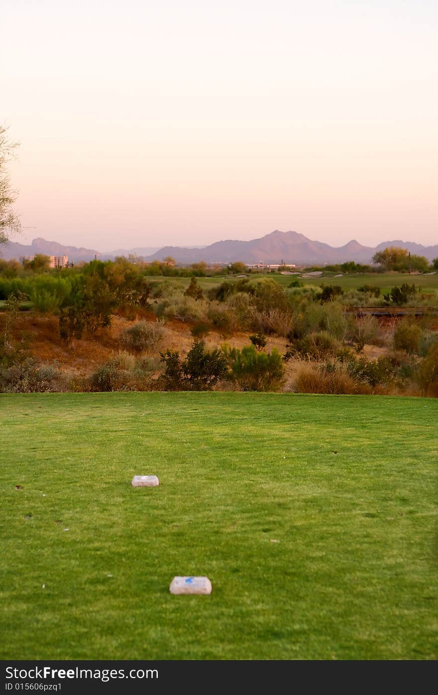 Golf course in the Arizona desert with mountains in the late afternoon sun