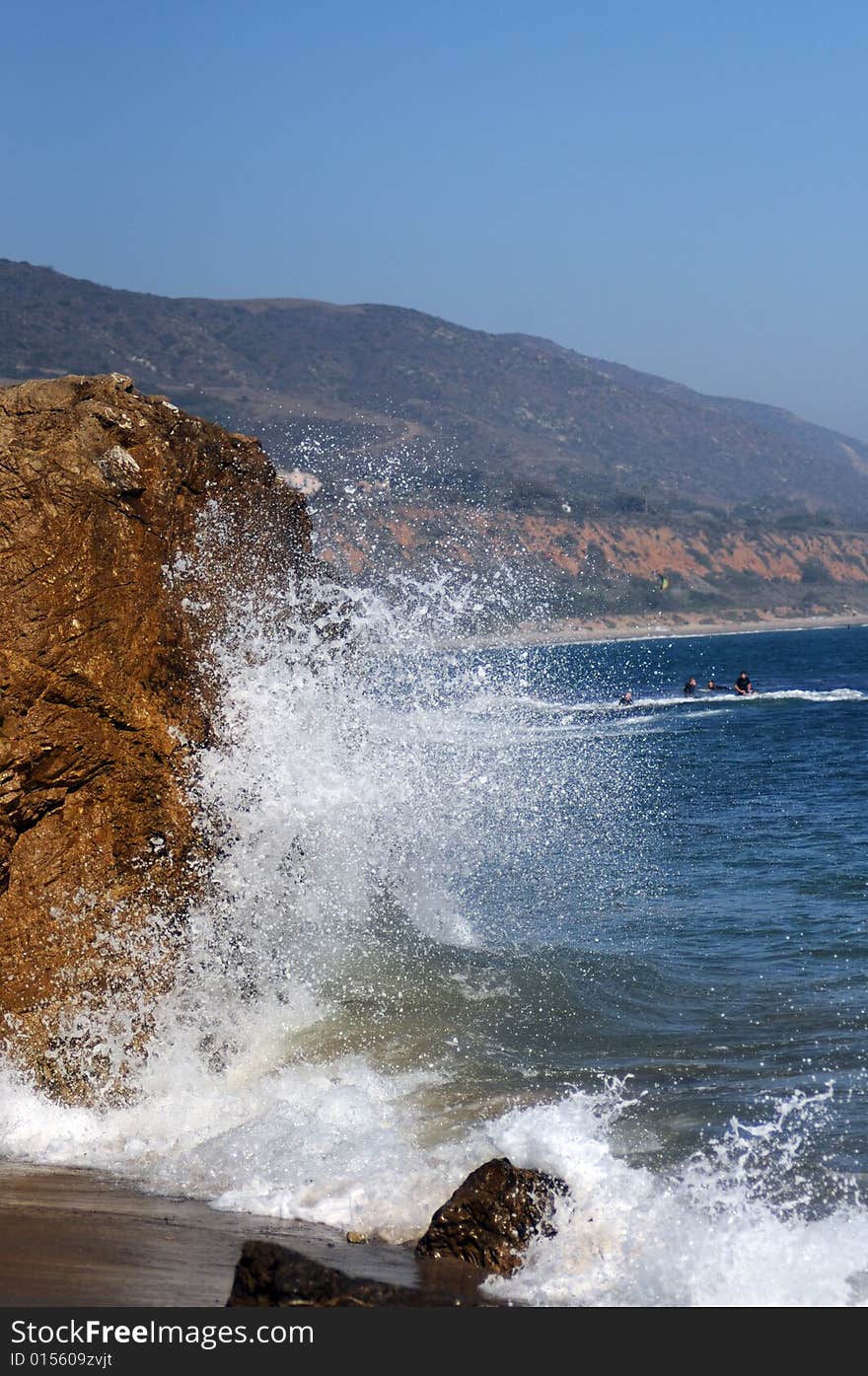 Wave crashing into rock on a beach