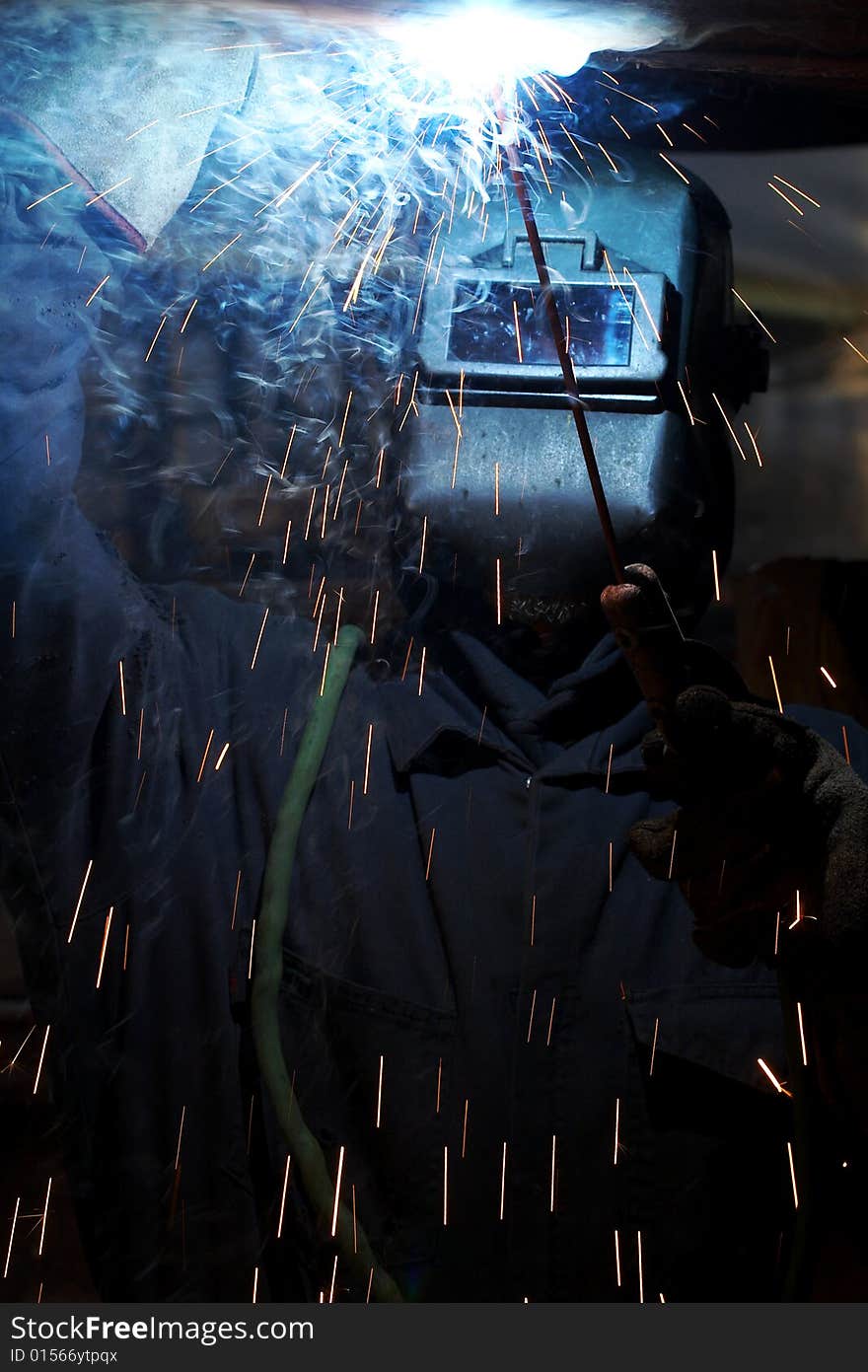 A welder working at shipyard under vessel. A welder working at shipyard under vessel