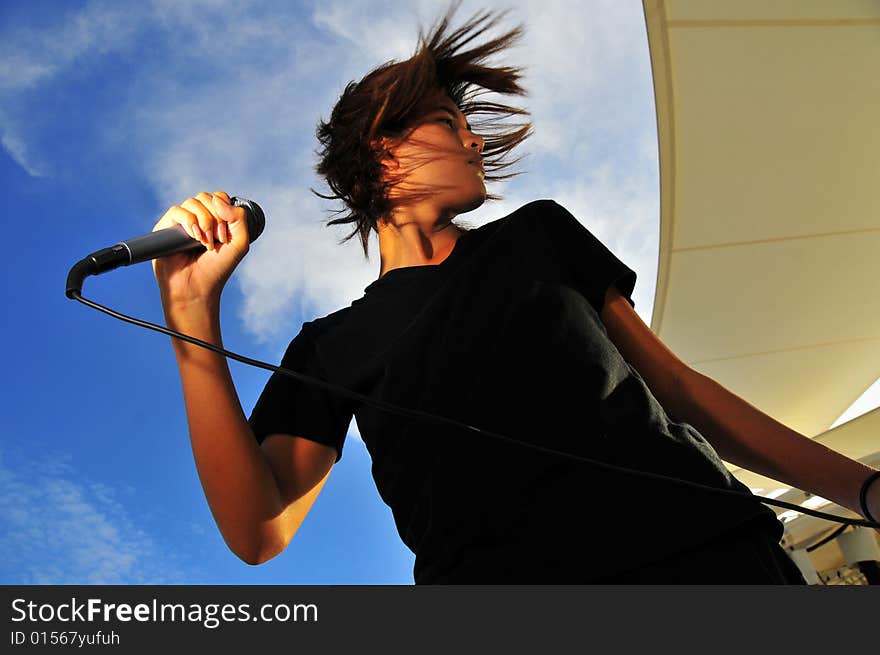 Picture of a young generation rock star with a microphone. Suitable for musical related contexts. Picture of a young generation rock star with a microphone. Suitable for musical related contexts.