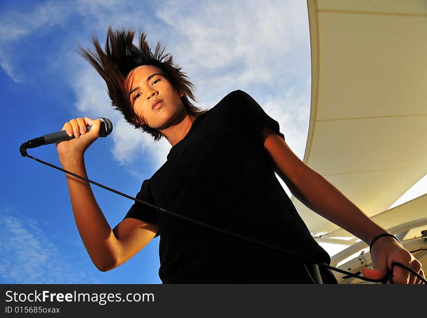 Picture of a young generation rock star with a microphone. Suitable for musical related contexts. Picture of a young generation rock star with a microphone. Suitable for musical related contexts.