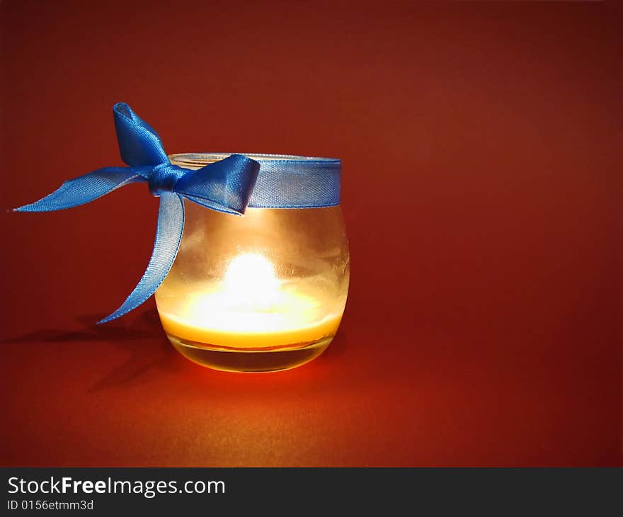 Candle in glass bottle with blue bow