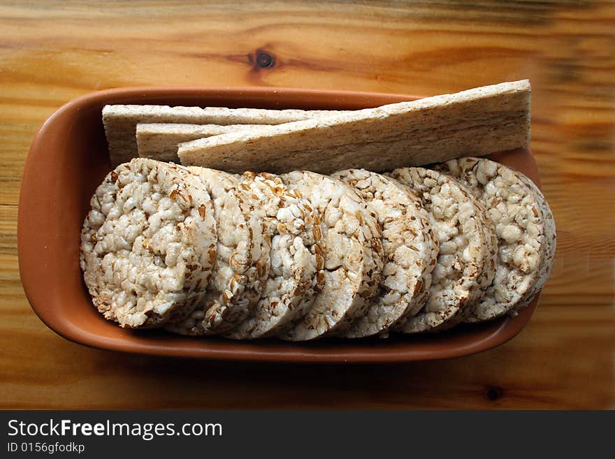 Crackers in brown bowl on wooden table. Crackers in brown bowl on wooden table