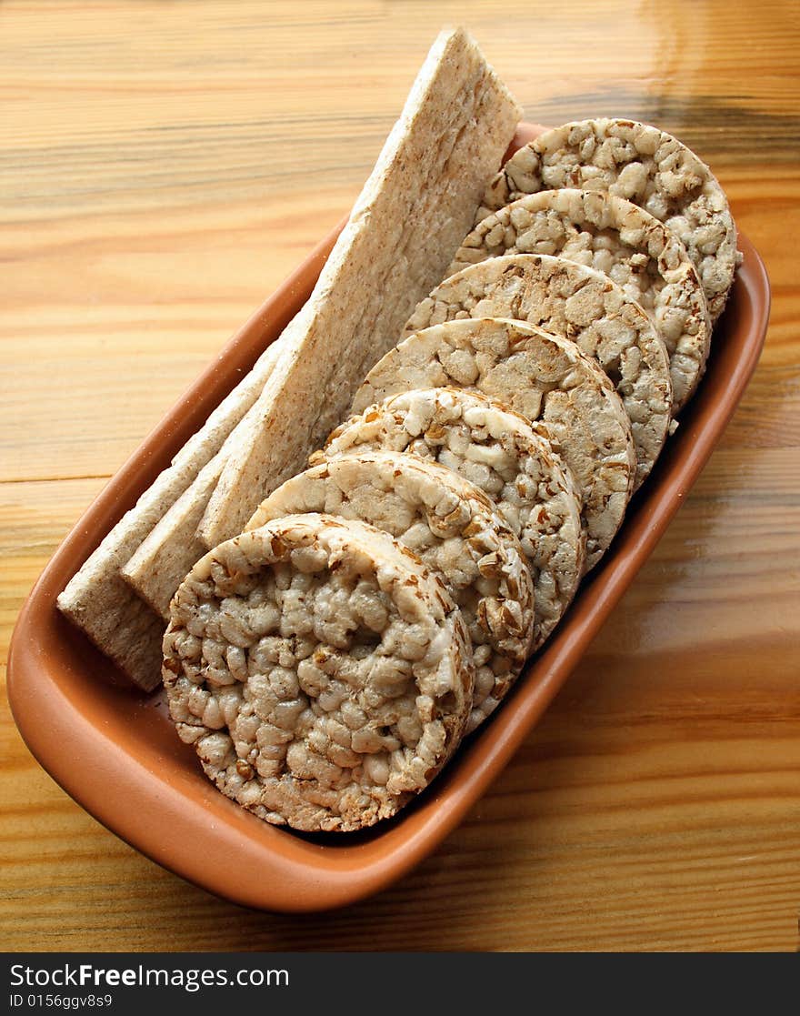 Crackers in brown bowl on wooden table. Crackers in brown bowl on wooden table