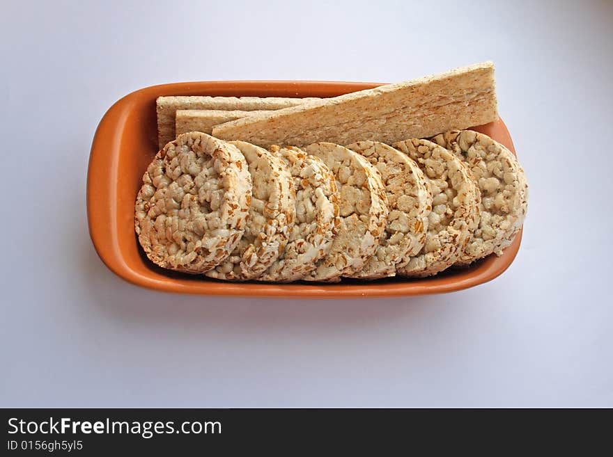 Crackers in brown bowl on white table. Crackers in brown bowl on white table