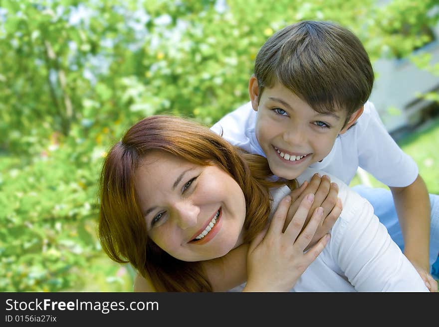 Portrait of happy mother with her son in summer environment