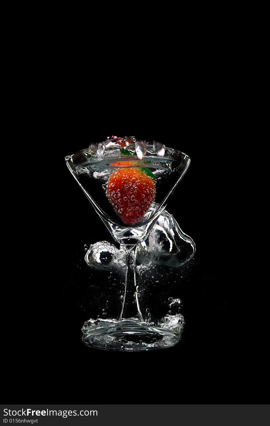 View of  martini glass with strawberry on black background. View of  martini glass with strawberry on black background