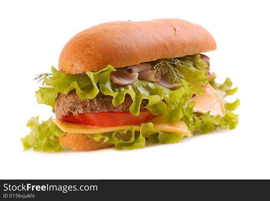 Big hamburger with slices of cheese, lettuce, bacon, beef,tomato, drill