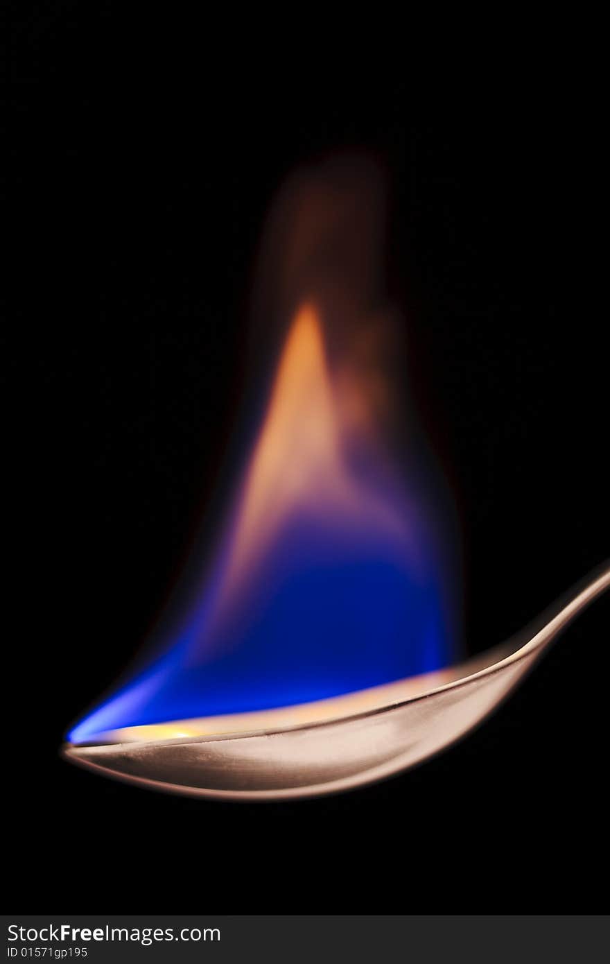 Close up of flaming spoon over black background