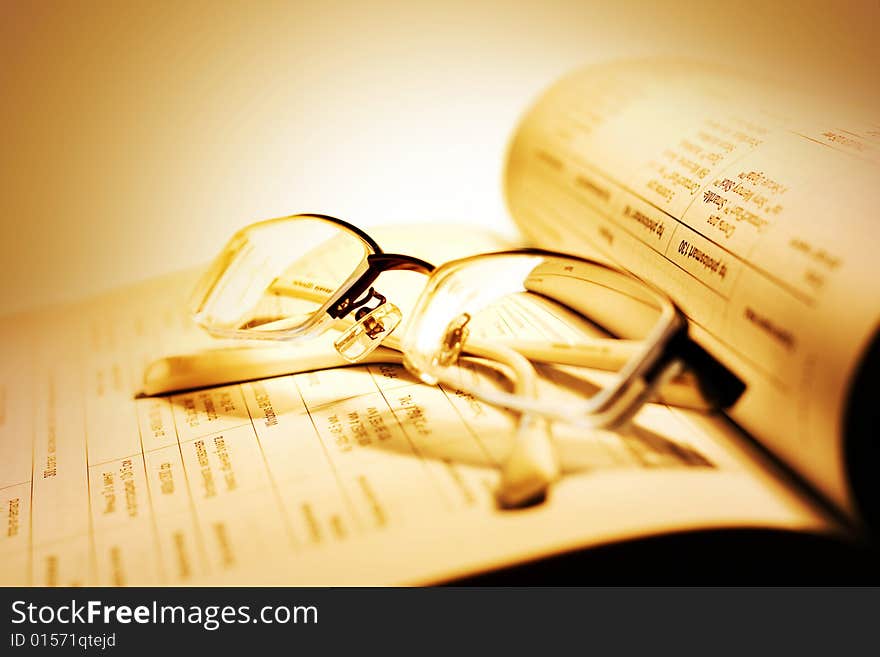 Book and Glasses on yellow background