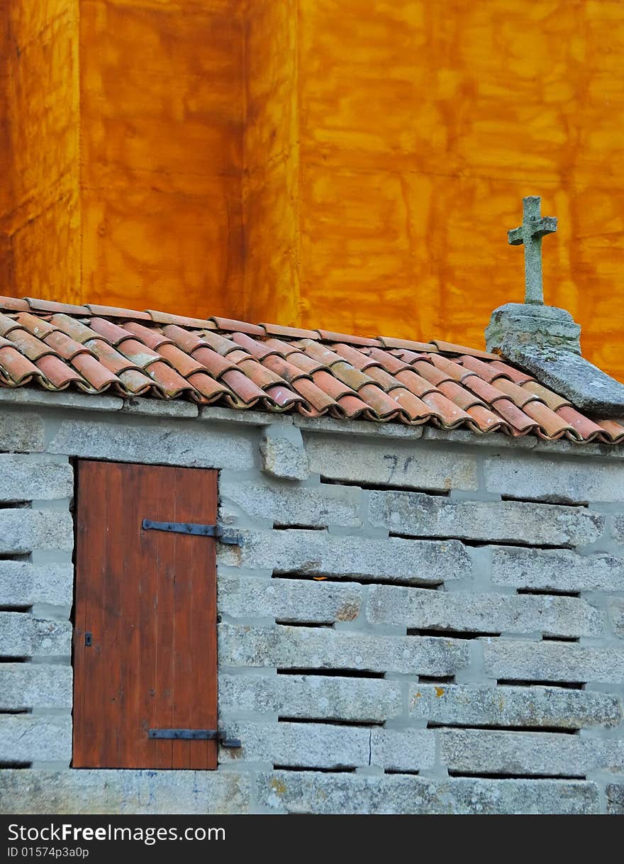 Traditional Galician granary in front of orange facade. Traditional Galician granary in front of orange facade