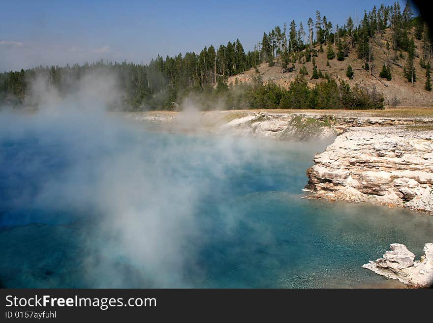 Blue lake with geysers in Yellowstone National Park