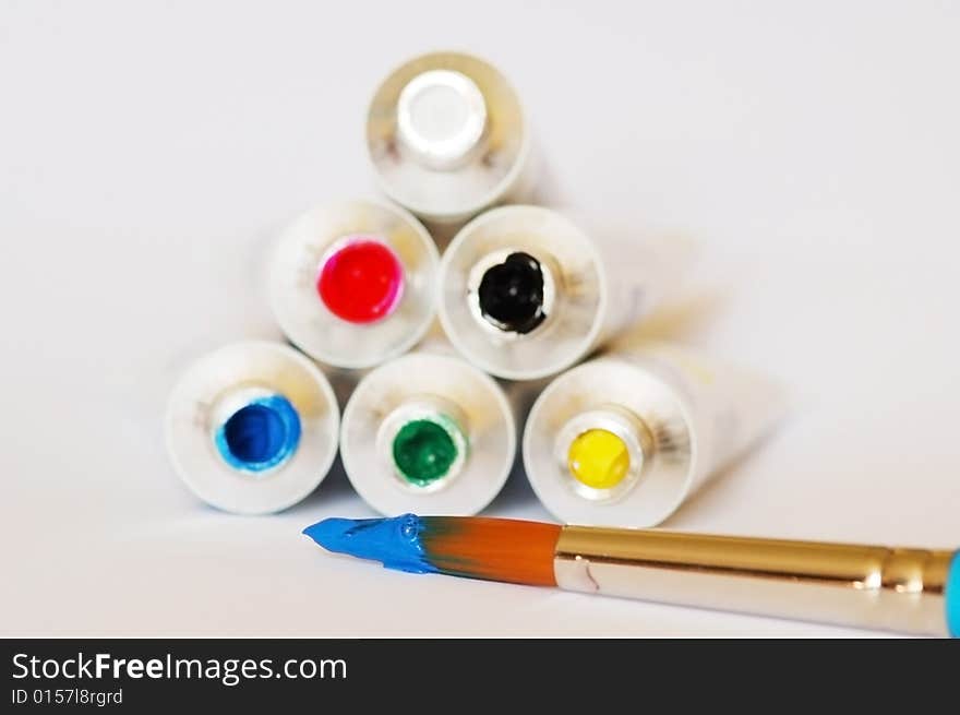 Red, blue, green, yellow, black and white gouache colors with the brush in white background. Red, blue, green, yellow, black and white gouache colors with the brush in white background