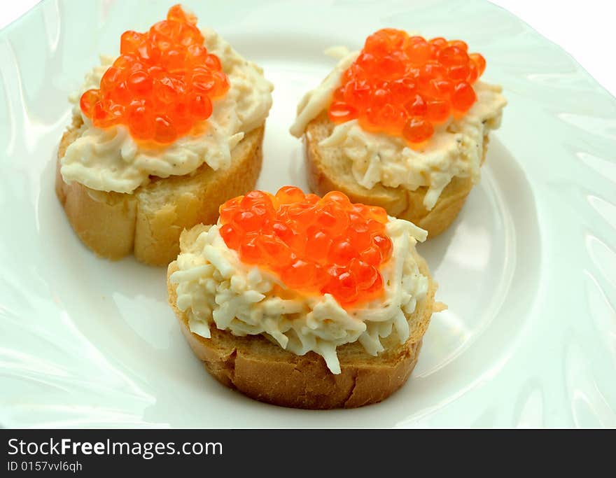 Three caviar sandwiches on white plate