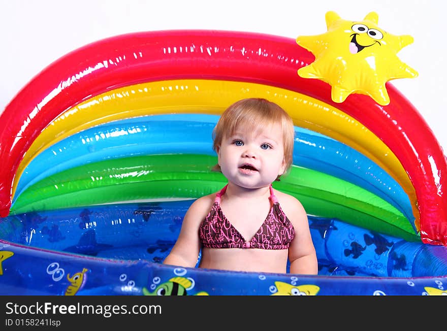 An adorable baby girl plays in her pool. An adorable baby girl plays in her pool.