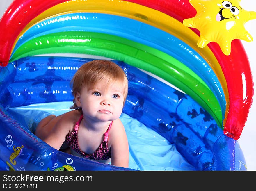 An adorable baby girl plays in her pool. An adorable baby girl plays in her pool.