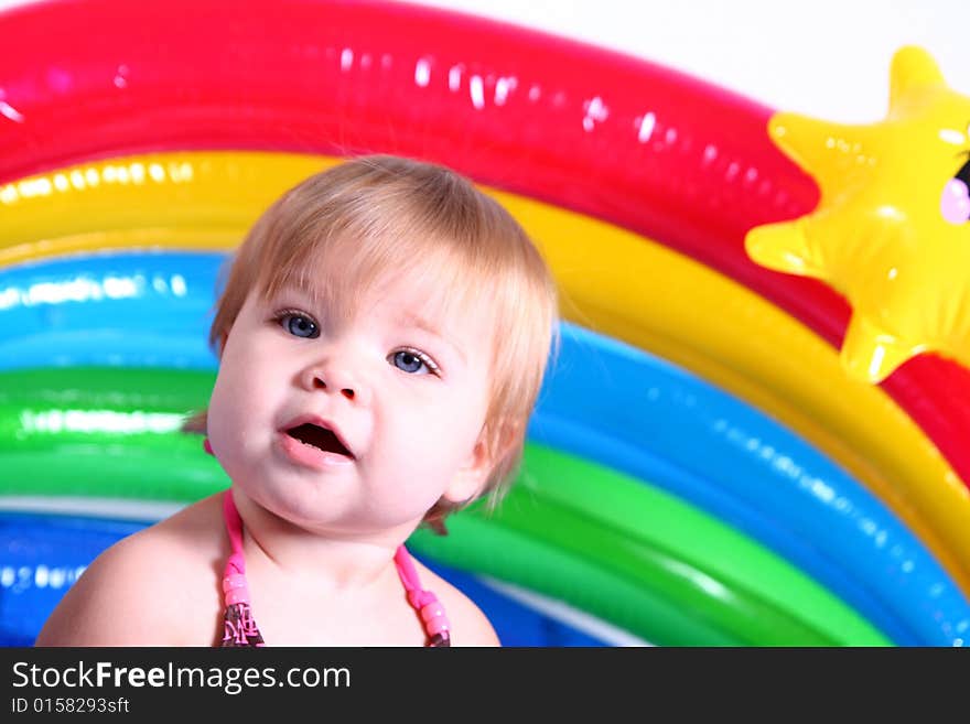 An adorable baby girl plays in her pool. An adorable baby girl plays in her pool.