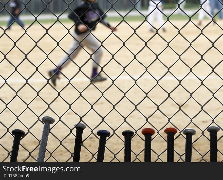 Baseball bats learning against dugout fence as game is played