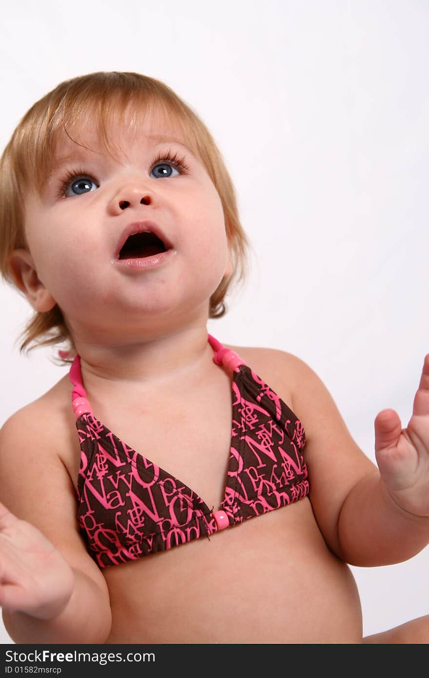 An adorable baby girl surprised while she claps her hands. An adorable baby girl surprised while she claps her hands.