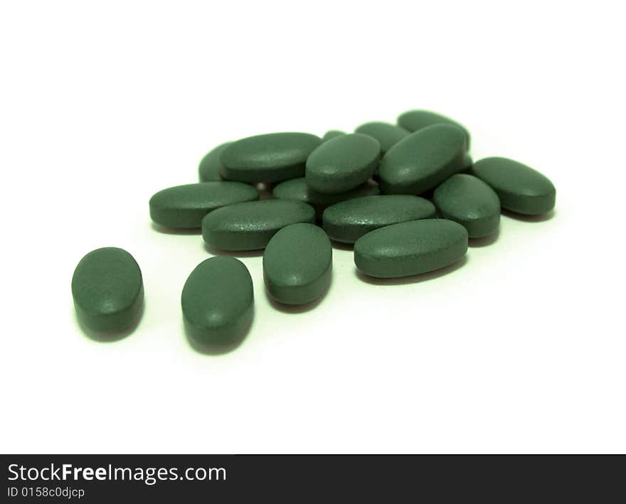 Green pills on white background. Green pills on white background