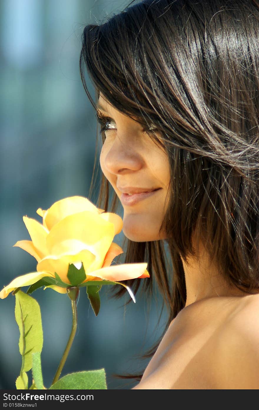 Young woman with a beautiful yellow rose